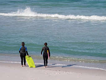 Deirdre and Clair heading out with their body boards